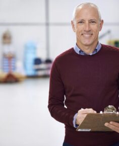 Portrait of a factory manager standing with a clipboard